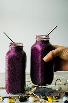 two mason jars filled with purple liquid sitting on top of a table