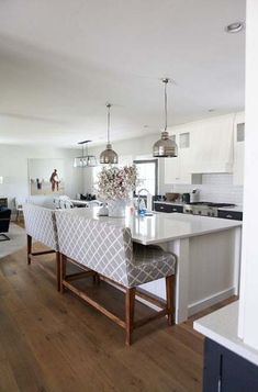 a large kitchen with an island in the middle and two chairs at the counter top