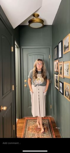 a woman standing in front of a door with her hands on her hips and looking at the camera