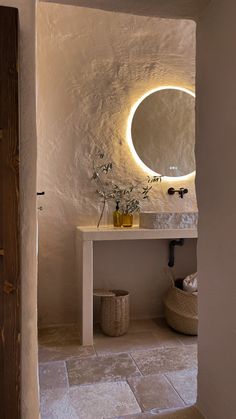 a bathroom with a sink, mirror and vase on the counter in front of it