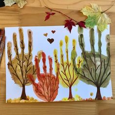 an art project with watercolors on paper and leaves in the shape of trees