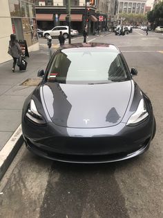 a tesla car parked on the side of the road