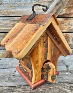 a wooden birdhouse with an umbrella attached to it's roof and door handle