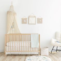 a baby's room with a crib, rocking chair and pictures on the wall