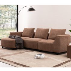 a brown couch sitting on top of a rug in a living room