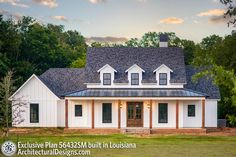 a large white house sitting in the middle of a lush green field