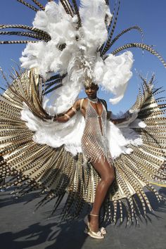 a woman is dressed in white and gold feathers