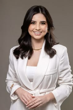 a woman in a white suit posing for a photo with her hands on her hips