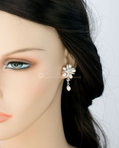 a mannequin head wearing a pair of earrings with pearls on it's ear