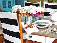 a dining room table with plates and flowers in vases