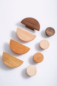 several wooden objects are arranged on a white surface