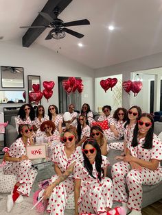 a group of women dressed in red and white polka dot pajamas posing for the camera