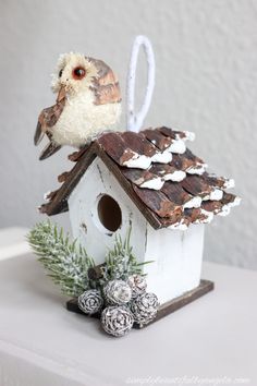 a small birdhouse with a white and brown bird on top