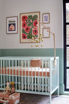 a baby's room with a crib and pictures on the wall