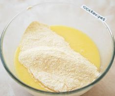 a glass bowl filled with yellow liquid and flour