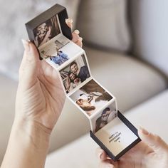 a woman holding up an open photo album with photos on it's sides and the inside