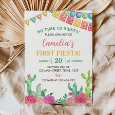 a birthday party is set up on a bed with pink and green flowers, including cacti