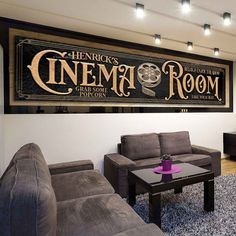 a living room filled with furniture and a large sign on the wall above it that says cinema room