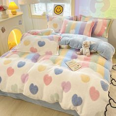 a bed with colorful polka dots and a stuffed animal on the comforter next to it