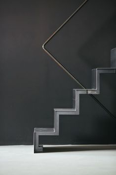 a black and white photo of a stair with a light on it's side