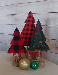 three small christmas trees on top of a table