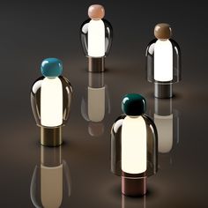 four different colored figures standing in the middle of a dark room with reflective flooring