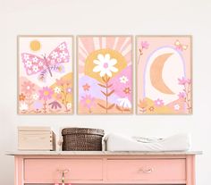 three paintings on the wall above a dresser in a room with pink furniture and white walls