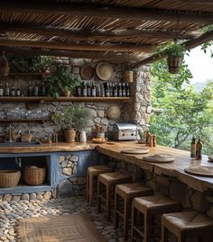 an outdoor kitchen with stone walls and counter tops, surrounded by wooden stools that are lined up against the wall