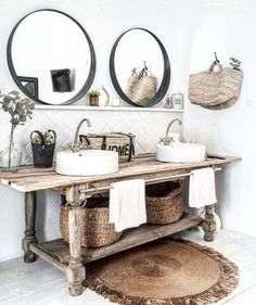 a bathroom with two sinks and mirrors on the wall next to each other in front of candles