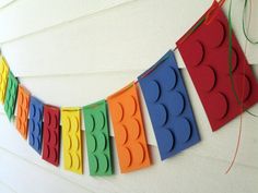 a paper banner made to look like legos is hanging on the wall with string