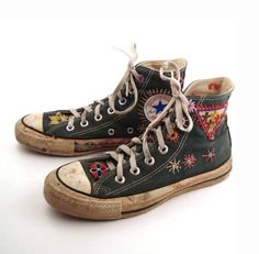 an old pair of black converse sneakers with colorful embroidered designs on them, side by side