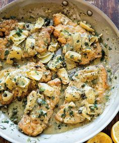 chicken with lemon sauce in a pan on a wooden table