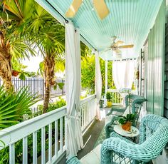 a porch with wicker furniture and palm trees