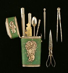 an assortment of kitchen utensils and spoons are arranged in a green tin