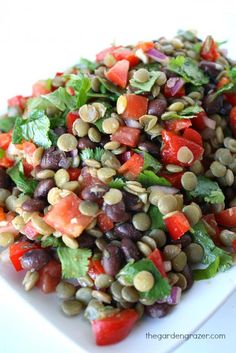 a white plate topped with a salad covered in beans and veggie toppings