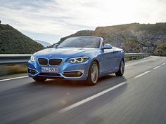 a blue bmw convertible driving down the road