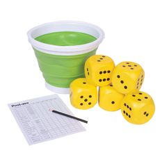 the dice is next to some sort of bucket with green liquid in it and several pieces of paper on the table