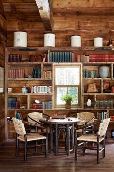 a table and chairs in a room with bookshelves