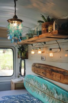 a blue surfboard sitting on top of a wooden shelf next to a light fixture