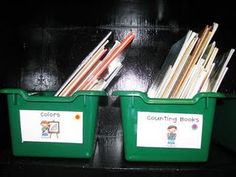 two green bins filled with books and pencils