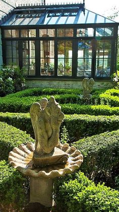 a garden with hedges and a fountain in the middle