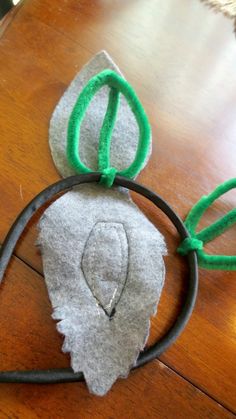 a mouse ears headband made out of felt on a wooden table next to a pair of scissors