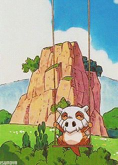 an animal is sitting on a swing in front of a rock formation and the sky