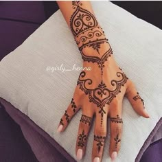 a woman's hand with henna tattoos on it