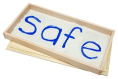 the word safe is written in blue ink on a wooden tray with two erasers