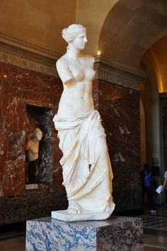 there is a marble statue in the middle of a room with people looking at it