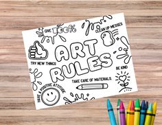 art rules coloring page with markers and crayons on wooden table next to it