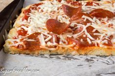 a square pizza with pepperoni and cheese on it in a baking pan, ready to be eaten