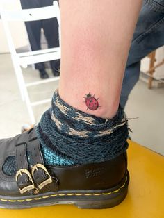 a small ladybug tattoo on the ankle