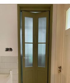 a bathroom with a green door and tiled floor